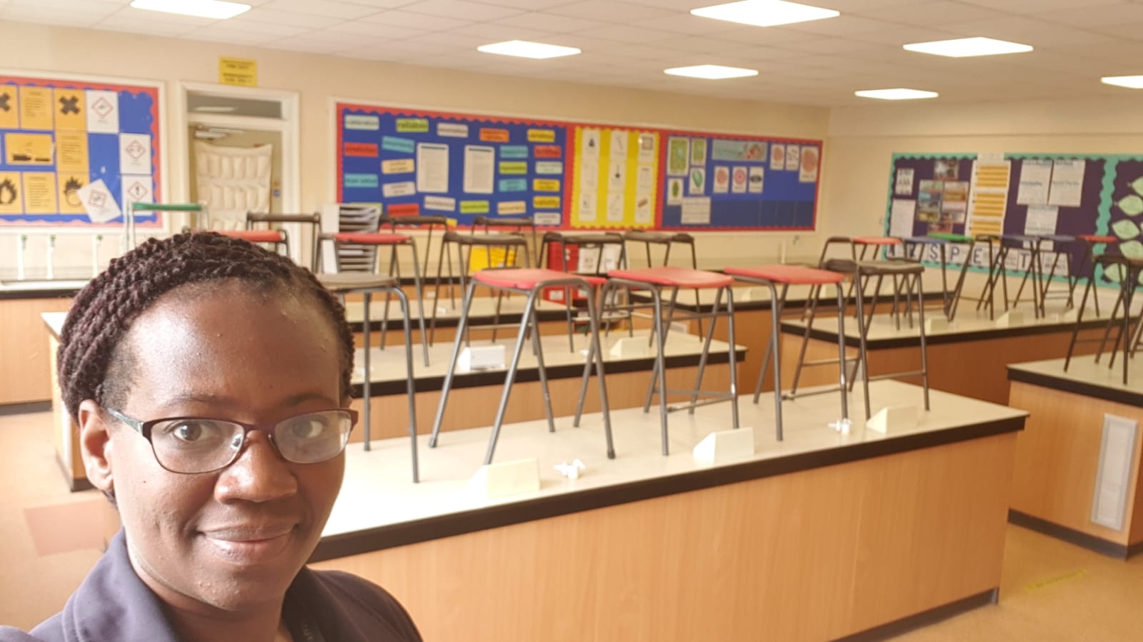 Sasha in an empty classroom with chairs on the tables